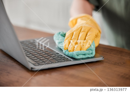 Person, hands and cleaning laptop for disinfection, bacteria or germ removal on wooden table at home. Closeup of housekeeper, cleaner or maid wiping computer in sanitizing, hygiene or clean equipment Person, hands and cleaning laptop for disinfection, bacteria or germ removal on wooden table at home. Closeup of housekeeper, cleaner or maid wiping computer in sanitizing, hygiene or clean equipment 136313977