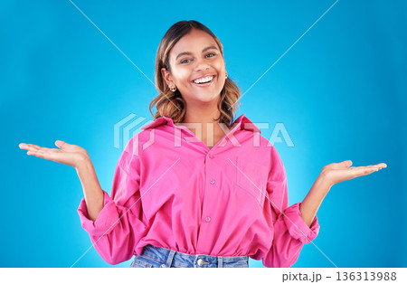 Space, choice and presentation with portrait of woman in studio for decision, show and information. Offer, advertising and deal with face of person on blue background for thinking, option and mockup Space, choice and presentation with portrait of woman in studio for decision, show and information. Offer, advertising and deal with face of person on blue background for thinking, option and mockup 136313988