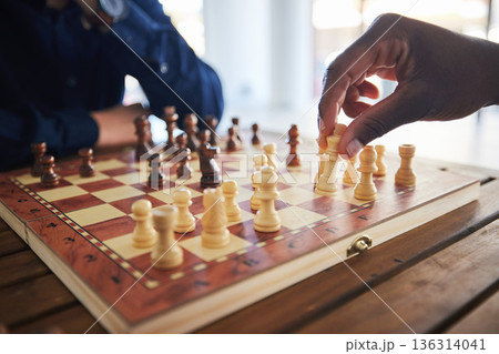 Hands, fun and people with a chess game, strategy and playing together at a competition. Table, professional and friends with a board for gaming, learning and expert with a skill or hobby in a room 136314041