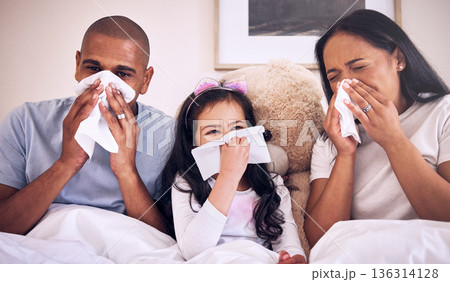 Family, sick and blowing nose on a bed together in a bedroom with allergy or virus and wipe with tissue. Disease, mother and father with kid or child with cold, flu and in winter as parents and girl 136314128