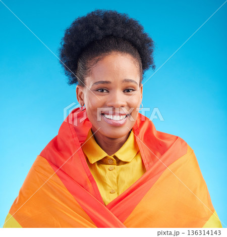 Pride, flag and portrait of black woman in studio for gay, rights and lgbtq lifestyle on blue background. Rainbow, freedom and face of lesbian African female happy, smile and confident with sexuality 136314143