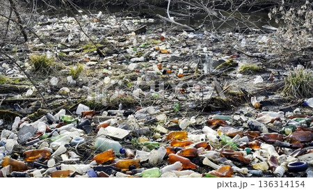 Dirty river is polluted with many plastic bottles. A lot of trash is dumped in open and freely available places at nature. Global environmental pollution problem. Concept of ecological disaster Dirty river is polluted with many plastic bottles. A lot of trash is dumped in open and freely available places at nature. Global environmental pollution problem. Concept of ecological disaster 136314154