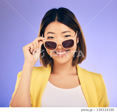 Happy asian woman, portrait and sunglasses for fashion or stylish accessory against a purple studio background. Female person or model with smile in satisfaction or relax for summer style or clothing 136314190