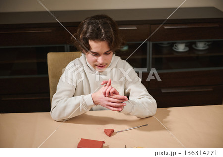 Young Boy Molding Clay at Home Table During Hobby Time Young Boy Molding Clay at Home Table During Hobby Time 136314271
