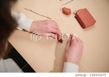 Hands Molding Red Clay Block During Craft Hobby Session in Studio Space Hands Molding Red Clay Block During Craft Hobby Session in Studio Space 136314275