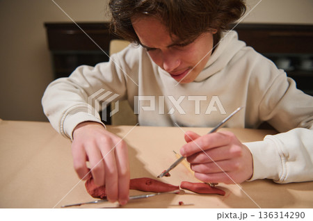 Focused Boy Molding Clay At Home: Hobbyist Creating Small Sculptures Focused Boy Molding Clay At Home: Hobbyist Creating Small Sculptures 136314290
