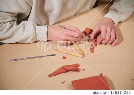 Child At Home Sculpting With Clay, Focused On Small Red Figures And Tools Child At Home Sculpting With Clay, Focused On Small Red Figures And Tools 136314296