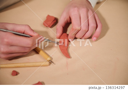 Child Hands Shaping Red Clay With Tools For Home Art Project Child Hands Shaping Red Clay With Tools For Home Art Project 136314297