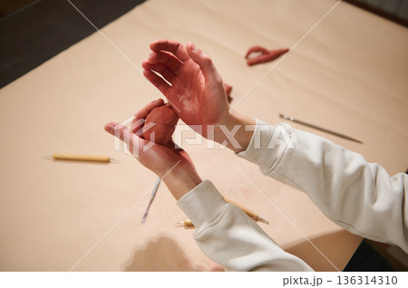 Hands Molding Red Clay With Tools On Table During Home Pottery Hobby 136314310