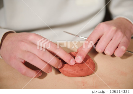 Child Hands Molding Red Clay at Home, Creative Hobby Activity 136314322
