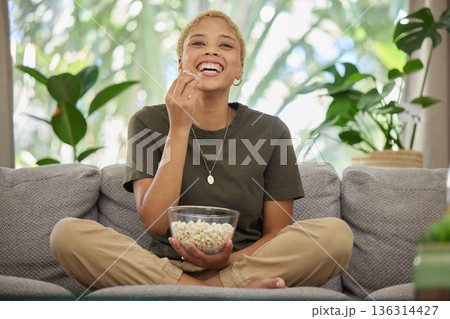 Woman on couch, popcorn and watch a movie with comedy and entertainment, streaming service and relax at home. Female person, subscription and internet, watching funny film or series with cinema snack Woman on couch, popcorn and watch a movie with comedy and entertainment, streaming service and relax at home. Female person, subscription and internet, watching funny film or series with cinema snack 136314427