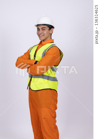 Confident construction worker in reflective vest crossing arms 136314625