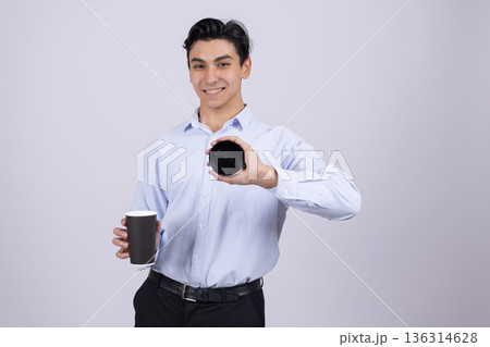 Young man in white shirt holding black takeaway coffee cup 136314628