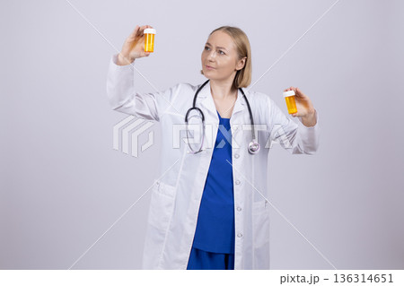Doctor in white coat holding pill bottle and tablet Doctor in white coat holding pill bottle and tablet 136314651