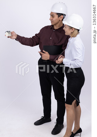 Engineer pointing at something to his colleague in studio Engineer pointing at something to his colleague in studio 136314667