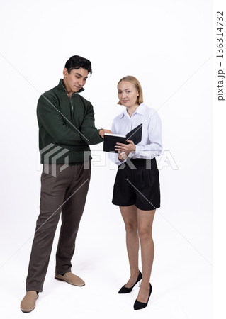 Young couple in school uniform discussing something 136314732