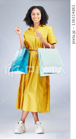 Portrait, smile and woman with shopping bag for fashion in studio isolated on a white background. Happy, sales and African customer with gift, discount deal or clothes from shop, mall or retail store Portrait, smile and woman with shopping bag for fashion in studio isolated on a white background. Happy, sales and African customer with gift, discount deal or clothes from shop, mall or retail store 136314861