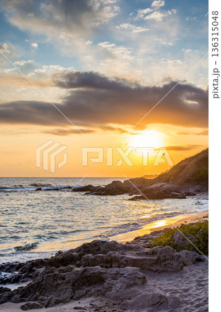 landscape of black sea sandy beach at sunrise. golden sand and rocks on the coast of bulgaria. beautiful view with sun above horizon. european summer vacation season and leisure concept 136315048