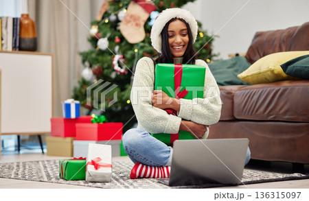 Woman, Christmas present and laptop, video call and celebrate holiday, happiness and communication. Virtual conversation, contact on pc and female person at home with gift giving, package and smile 136315097