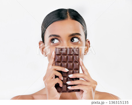 Woman, thinking and chocolate in sweet diet or unhealthy eating against a white studio background. Female person or model with cocoa slab, block or bar in delicious treat, snack or diabetes on mockup 136315135