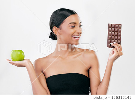 Apple, chocolate and woman with healthy food choice or offer isolated on studio, white background for sugar and diet. Dessert, green fruit and young person with detox, vegan or lose weight decision Apple, chocolate and woman with healthy food choice or offer isolated on studio, white background for sugar and diet. Dessert, green fruit and young person with detox, vegan or lose weight decision 136315143