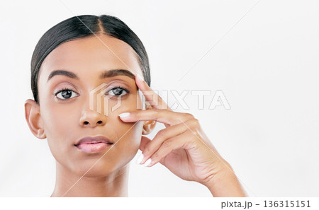 Beauty, hand on face and portrait of a woman with natural skin glow isolated on a white background. Dermatology, makeup and cosmetics of Indian female model for facial shine or self care in studio 136315151