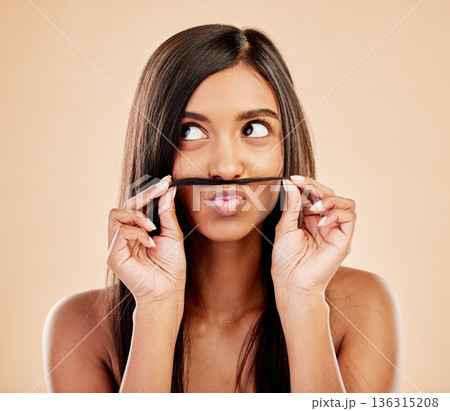 Face, skincare and hair mustache with a woman in studio on a cream background for keratin treatment. Beauty, haircare and funny with happy young female looking playful at the salon or hairdresser Face, skincare and hair mustache with a woman in studio on a cream background for keratin treatment. Beauty, haircare and funny with happy young female looking playful at the salon or hairdresser 136315208