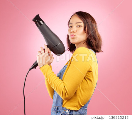 Hairdryer, kiss and hair care with portrait of woman in studio for hairdresser, beauty and cosmetics. Shampoo, salon and hairstyle with funny face of person on pink background for product and glow Hairdryer, kiss and hair care with portrait of woman in studio for hairdresser, beauty and cosmetics. Shampoo, salon and hairstyle with funny face of person on pink background for product and glow 136315215