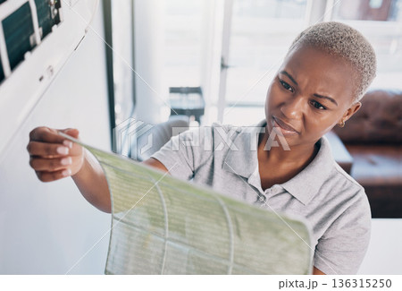 Dirty, cleaning and a black woman with a wall cover for maintenance, building or home renovation. Dust, construction and an African girl or cleaner with a trash, waste or garbage problem in a house 136315250