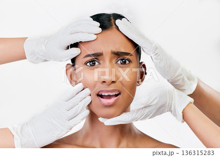 Plastic surgery, scared and face of woman with hands of prp doctors on white background in studio. Beauty, portrait and indian female model with fear, stress and anxiety for facial aesthetic change 136315283
