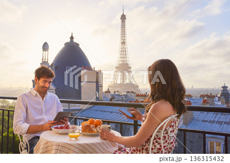 Travel, breakfast and couple in Paris with the Eiffel Tower on a terrace for romance or anniversary. City, vacation or tourism tech app with a man and woman eating food while looking at a view Travel, breakfast and couple in Paris with the Eiffel Tower on a terrace for romance or anniversary. City, vacation or tourism tech app with a man and woman eating food while looking at a view 136315432