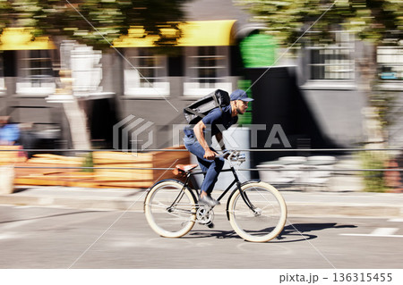 Delivery, man or motion blur on bike in city for quick logistics, service or fast food order. Courier, postman or travel for speed on bicycle transportation with parcel, package or trip in urban road 136315455