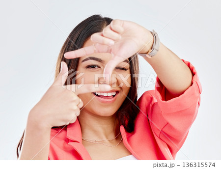 Happy, portrait of a woman with hand frame and against a white background. Social media or creativity, face or smile and female person pose with gesture for perfect photography in studio backdrop 136315574