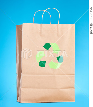 Brown paper bag, recycling sign and studio for sustainability, shopping and retail package by blue background. Eco friendly product, climate change and design for social responsibility to save planet Brown paper bag, recycling sign and studio for sustainability, shopping and retail package by blue background. Eco friendly product, climate change and design for social responsibility to save planet 136315639