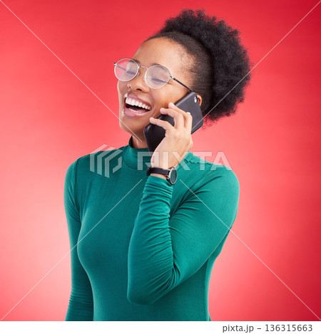 Happy woman, phone call and laughing for funny joke, meme or conversation against a red studio background. Female person smile and laugh for fun discussion or social media on mobile smartphone 136315663