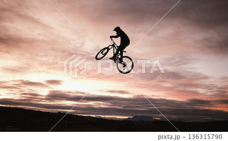 Sunset, dirt bike and jump with action in outdoor with sport in nature for adventure or risk. Motorcycle, silhouette and freedom with training or sky with speed in desert with person driving. 136315790