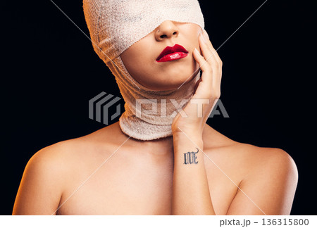 Bandage, plastic surgery and a woman with cosmetics on a dark background for a medical procedure. Beauty, healing and a girl or model after botox or facial change isolated on a studio backdrop Bandage, plastic surgery and a woman with cosmetics on a dark background for a medical procedure. Beauty, healing and a girl or model after botox or facial change isolated on a studio backdrop 136315800