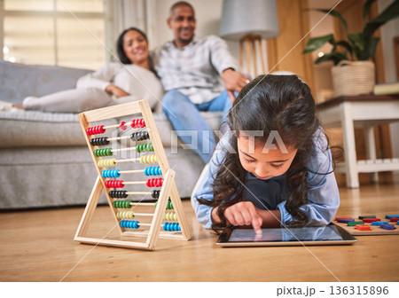 Child, toys for learning and tablet for education in family home with abacus on the floor with mom, dad in living room with a game. Girl, development in math and couple together on couch in house Child, toys for learning and tablet for education in family home with abacus on the floor with mom, dad in living room with a game. Girl, development in math and couple together on couch in house 136315896