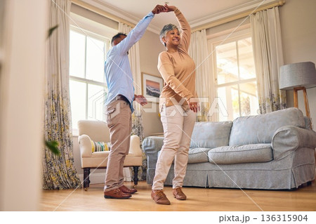 Retirement, romance and dance with a senior couple in the living room of their home together for bonding. Marriage, love or fun with an elderly man and woman dancing in the lounge of their house Retirement, romance and dance with a senior couple in the living room of their home together for bonding. Marriage, love or fun with an elderly man and woman dancing in the lounge of their house 136315904