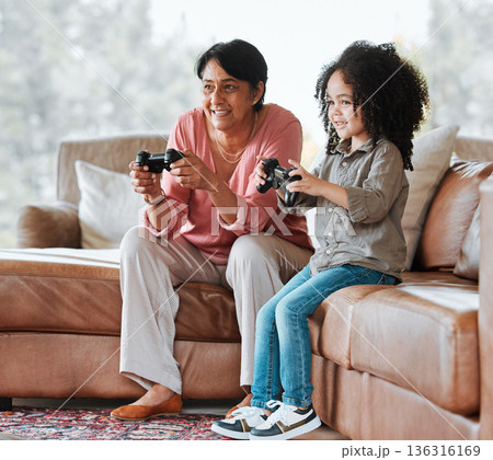 Grandma, child and video game on couch, controller and happy together with bond, contest and love in lounge. Senior woman, young kid and playing with gaming, esports and competition in family house Grandma, child and video game on couch, controller and happy together with bond, contest and love in lounge. Senior woman, young kid and playing with gaming, esports and competition in family house 136316169