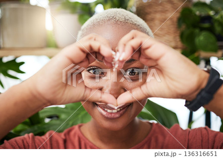 Black woman, portrait and face with heart hands for love, sign or shape in natural wellness or eco friendly store. Happy African female person with loving emoji, symbol or gesture for care in garden Black woman, portrait and face with heart hands for love, sign or shape in natural wellness or eco friendly store. Happy African female person with loving emoji, symbol or gesture for care in garden 136316651