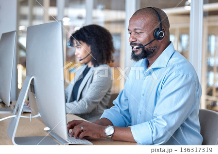 Call center, black man and consultant at computer for customer service, business support or help in CRM office. Happy telemarketing agent typing at desktop for telecom consulting in coworking agency Call center, black man and consultant at computer for customer service, business support or help in CRM office. Happy telemarketing agent typing at desktop for telecom consulting in coworking agency 136317319