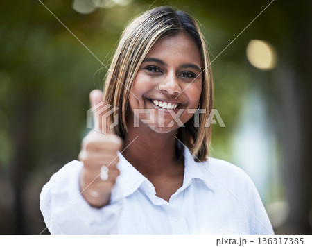 Portrait, smile and thumbs up with a woman in nature, outdoor on a green background for support or motivation. Face, thank you and like emoji with a happy young person standing in a park to say yes 136317385