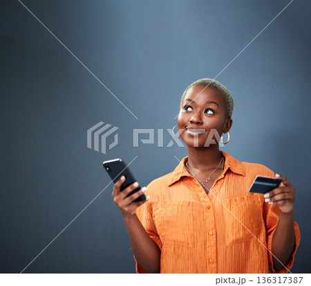 Thinking, ecommerce and credit card with a black woman using her phone in studio on a gray background. Mobile, online shopping and finance payment with a female shopper searching for a deal or sale Thinking, ecommerce and credit card with a black woman using her phone in studio on a gray background. Mobile, online shopping and finance payment with a female shopper searching for a deal or sale 136317387