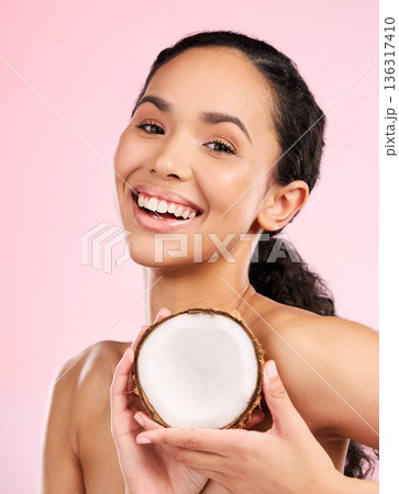 Woman face, coconut fruit and skincare, natural beauty or vegan cream on pink, studio background. Portrait of african person with healthy product for dermatology, skin care cosmetics and oil benefits Woman face, coconut fruit and skincare, natural beauty or vegan cream on pink, studio background. Portrait of african person with healthy product for dermatology, skin care cosmetics and oil benefits 136317410