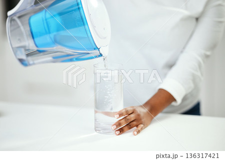 Hands, person and pitcher of filter water, glass and liquid hydration for purification at home. Closeup, thirsty woman and pouring healthy aqua beverage for nutrition, drinking and clean filtration Hands, person and pitcher of filter water, glass and liquid hydration for purification at home. Closeup, thirsty woman and pouring healthy aqua beverage for nutrition, drinking and clean filtration 136317421