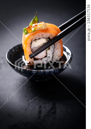 Japanese cuisine. Sushi rolls on a black platter 136317536