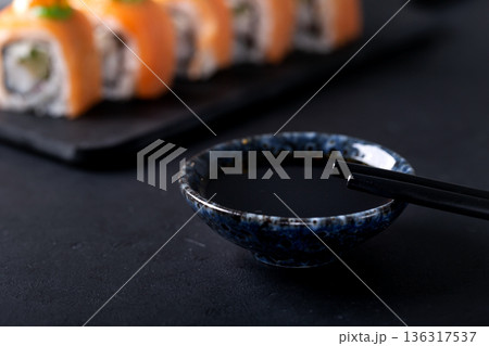 Japanese cuisine. Sushi rolls on a black platter 136317537
