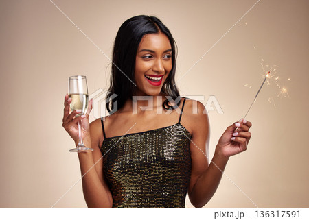 Happy woman, sparkler and celebration with party, Champagne and new year on studio background. Fireworks, alcohol drink in glass and holiday fun, luxury event and excited female person with sparks 136317591