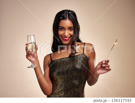 Portrait, woman and sparkler for celebration with Champagne, New Years party and fun on studio background. Fireworks, alcohol drink in glass and holiday, event and happy female person with sparks Portrait, woman and sparkler for celebration with Champagne, New Years party and fun on studio background. Fireworks, alcohol drink in glass and holiday, event and happy female person with sparks 136317593